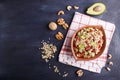 Salad of germinated buckwheat, avocado, walnut and pomegranate seeds in clay plate on black wooden background Royalty Free Stock Photo