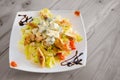 Salad with gorgonzola, chicken meat, tomato and lettuce on wooden table