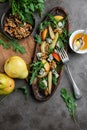 Salad with gorgonzola, rucola, pears, walnuts and honey in a long wooden plate.