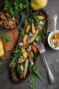 Salad with gorgonzola, rucola, pears, walnuts and honey in a long wooden plate.