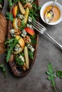 Salad with gorgonzola, rucola, pears, walnuts and honey in a long wooden plate.