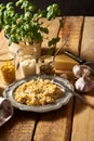 Salad of grated cheese with capers and corn with basil on wooden table