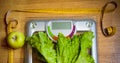 Salad, green apple, yellow measuring tape and weight scale Royalty Free Stock Photo