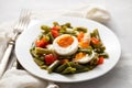 salad green beans, pepper and boiled eggs on white plate