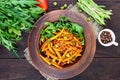 Salad from green beans, stewed with onions in tomato sauce and green leaves of arugula