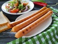 Salad green beans, tomato, gourmet dinner nutrition fried sausages on a wooden background, bread red pepper appetizing Royalty Free Stock Photo