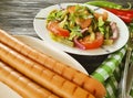 Salad green beans, tomato, gourmet nutrition plate fried sausages on a wooden background, bread red pepper appetizing Royalty Free Stock Photo