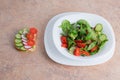 Salát z zelený zelenina rajče v bílý deska na stůl 