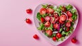 Salad Greens Mix in Heart Shape plate on pink background, Health Concept, Copy Space, Restaurant Valentine\'s day