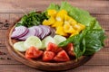 Salad of greens, tomatoes, cucumbers, sweet pepper onions on a wooden background Royalty Free Stock Photo