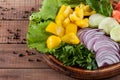 Salad of greens, tomatoes, cucumbers, sweet pepper onions on a wooden background Royalty Free Stock Photo