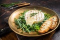 Salad with grilled Camembert cheese, arugula, toast and rosemary in a plate. Dark background. Top view Royalty Free Stock Photo