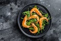 Salad with grilled giant tiger shrimps, prawns and arugula. Black background. Top view