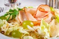Salad with ham, iceberg, pear, grape and pumpkin seeds on white plate. Royalty Free Stock Photo