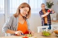 Appealing wife feeling joyful while cooking salad for husband Royalty Free Stock Photo