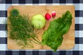 The salad ingredients are on the cutting Board. Clean vegetables - dill, kohlrabi cabbage, lettuce, radishes,sorrel, greens for Royalty Free Stock Photo