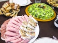 Salad with kiwi, ham, pieces of stuffed turkey, rolls with salmon at a Christmas dinner