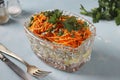 Salad with Korean carrots, ham, eggs, onion and mushrooms in a transparent salad bowl on a light blue background Royalty Free Stock Photo