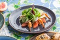 Salad with lettuce, shrimp and grapefruit on blue plate on the table Royalty Free Stock Photo