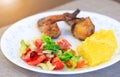 Salad, mamaliga or polenta, baked chicken legs in fancy plate. Traditional food and culinary culture specific for Balkan countries