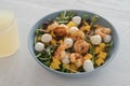 Salad with mango, mozzarella, shrimps and mixed microgreens in blue bowl on white oak table Royalty Free Stock Photo