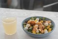 Salad with mango, mozzarella, shrimps and mixed microgreens in blue bowl on white oak table Royalty Free Stock Photo