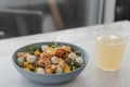 Salad with mango, mozzarella, shrimps and mixed microgreens in blue bowl on white oak table Royalty Free Stock Photo