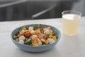 Salad with mango, mozzarella, shrimps and mixed microgreens in blue bowl on white oak table Royalty Free Stock Photo