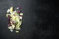 Salad with a mix of different salad leaves, like romaine lettuce, endive or arugula, on black stone background, top view flat lay Royalty Free Stock Photo
