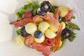 Salad of mixed summer berries. Seasonal summer salad with fruit and berries and Italian prosciutto meat Royalty Free Stock Photo