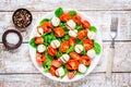 Salad of mozzarella, cherry tomatoes and spinach with salt and pepper