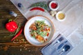 On a dark countertop, a light linen napkin, on a cutting board Salad with mussels, rucola, red caviar, shrimps in a round dish,