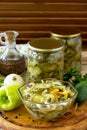 Salad with pickles and vegetables on the kitchen wooden background. Homemade pickle.