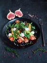 salad on a plate: arugula, cherry tomatoes, figs, grated cheese, black grapes Royalty Free Stock Photo