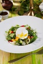 Salad with poached egg, cucumbers, arugula, cabbage, peppers, still life on a wooden table green chalkboard pretty food