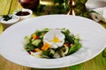 Salad with poached egg, cucumbers, arugula, cabbage, peppers, still life on a wooden table green chalkboard pretty food