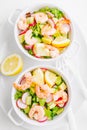 Salad with prawns in bowls on table