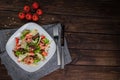 Salad with prosciutto and parmesan. Cherry Tomatoes, cutlery, knives, forks, and pine nuts on the table. Flat lay horizontal photo