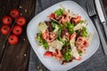 Salad with prosciutto and parmesan. Cherry Tomatoes, cutlery, knives, forks, and pine nuts on the table. Flat lay horizontal photo