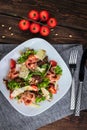 Salad with prosciutto and parmesan. Cherry Tomatoes and pine nuts on the table. Flat lay vertical photo