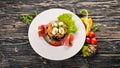 Salad with prosciutto, quail eggs, prunes and fresh vegetables on the plate. On a wooden background. Top view Royalty Free Stock Photo