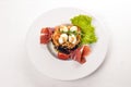 Salad with prosciutto, quail eggs, prunes and fresh vegetables on the plate. On a wooden background. Top view. Royalty Free Stock Photo