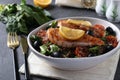 Salad with quinoa, salmon, spinach, black olives, lemon and cherry tomatoes in a plate on gray background. Healthy eating Royalty Free Stock Photo