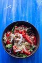 Salad quinoa with tuna, tomato and lettuce in brown bowl on blue background