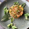 Salad with red salted salmon fish on a banana leaf with mash and microgrin