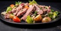 Salad with roast beef, potatoes and vegetables on a black plate Royalty Free Stock Photo