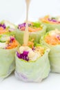 salad roll made from vegetable ingredients such as carrots, green cabbage, purple cabbage, cucumber, and roasted chicken