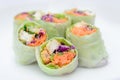 salad roll made from vegetable ingredients such as carrots, green cabbage, purple cabbage, cucumber, and roasted chicken