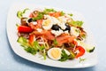 Salad with salmon, fresh tomato, cucumber and quail eggs at plate