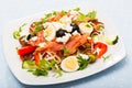 Salad with salmon, fresh tomato, cucumber and quail eggs at plate